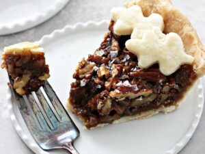 A slice of Dairy Free Pecan Pie with a bite taken out with a fork.