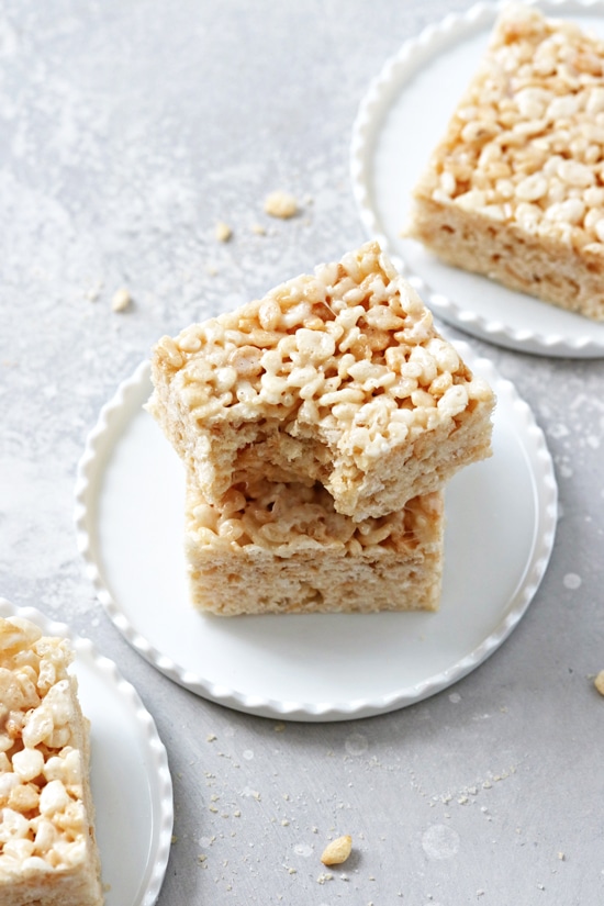 Coconut Oil Rice Krispie Treats on plates with a bite taken out of one.