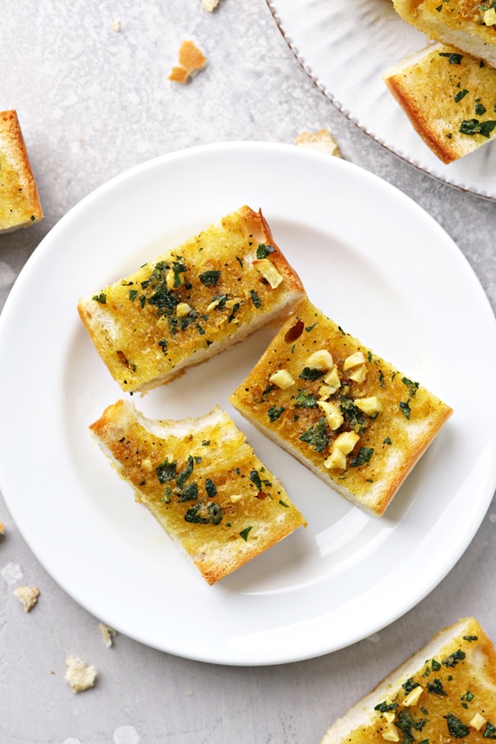 Three slices of Olive Oil Garlic Bread with a bite taken out of one.