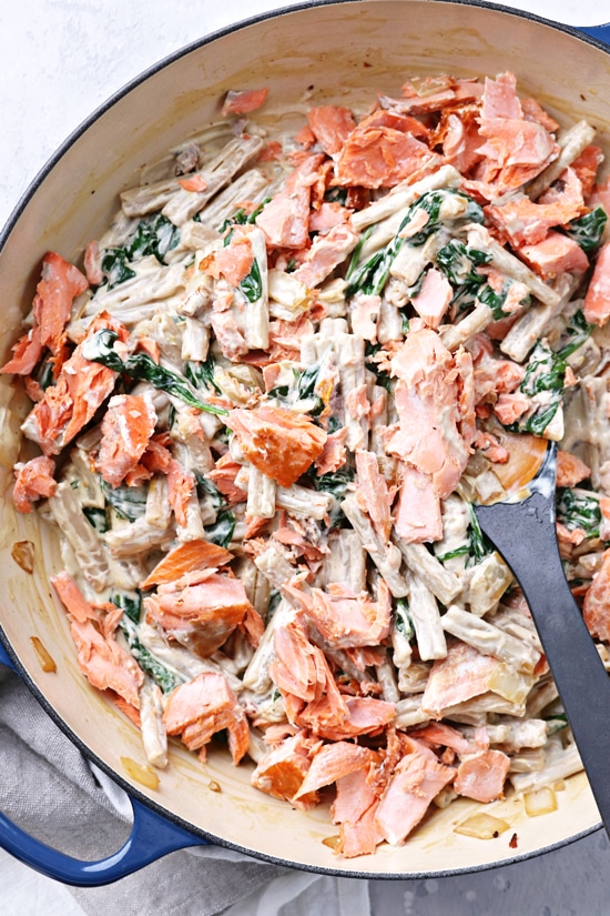 A blue skillet filled with Dairy Free Creamy Salmon Pasta.