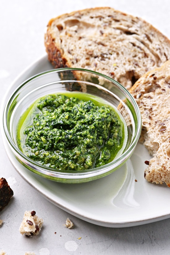 Dairy Free Pesto in a bowl with bread to the side.