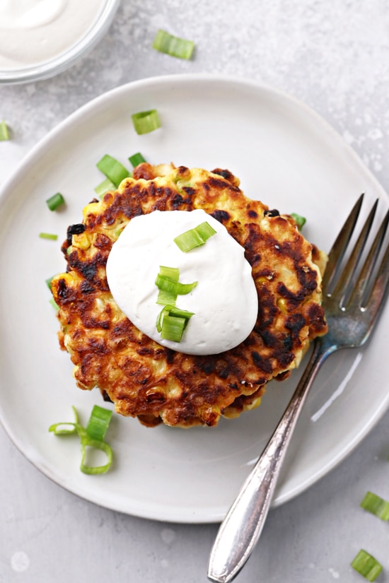 A stack of No Milk Corn Fritters on a plate with a fork.
