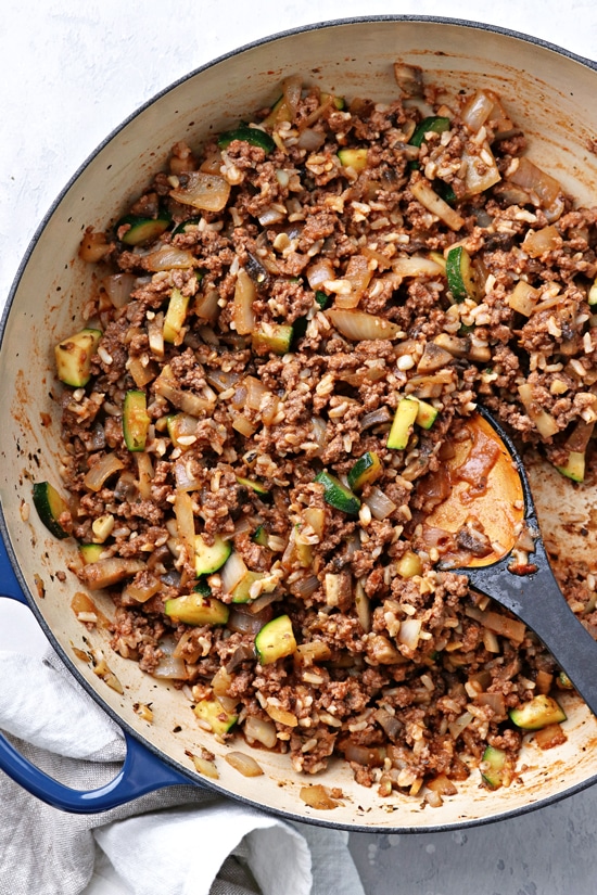 A skillet filled with ground meat, rice and veggies.