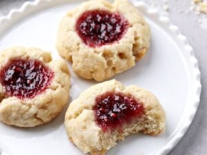 Three Dairy Free Thumbprint Cookies on a white plate.