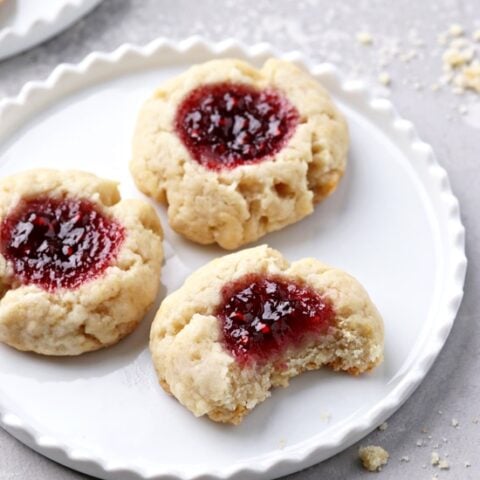 Three Dairy Free Thumbprint Cookies on a white plate.
