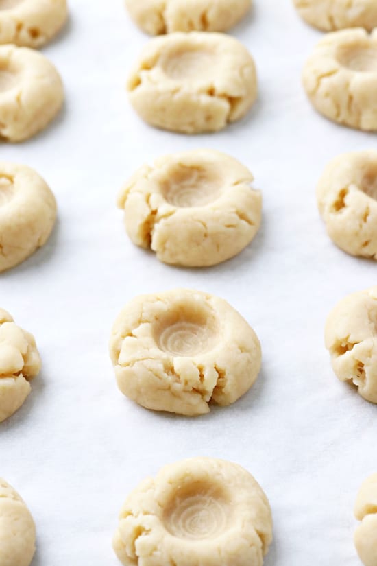 Unfilled thumbprint cookies on a baking sheet.