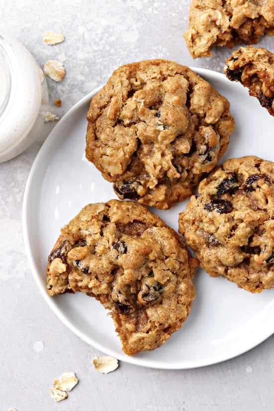 Dairy Free Oat and Raisin Cookies on a plate with a bite taken from one.