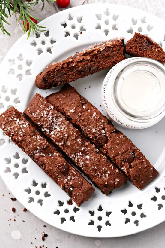 A plate with Vegan Chocolate Biscotti and a jar of milk.