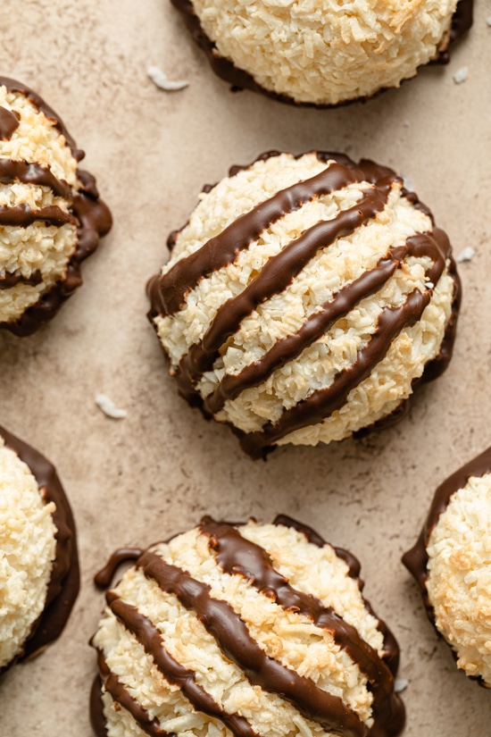 Several Dairy Free Coconut Macaroons on a beige surface.