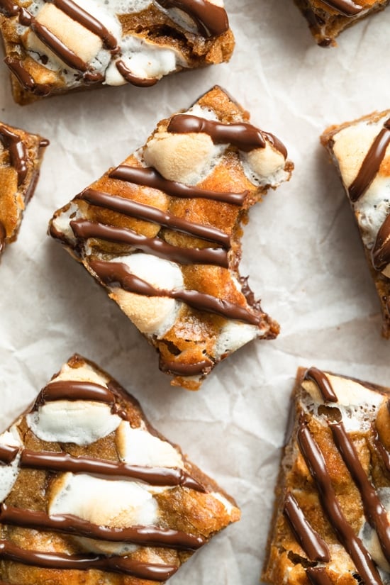 Several Dairy Free Cookie Bars on parchment with a bite taken from one.