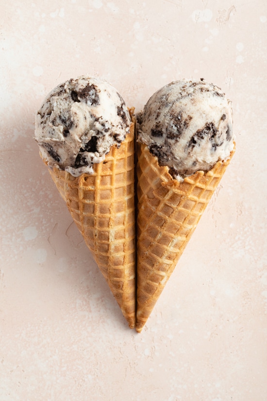 Two cones filled with Oat Milk Cookies and Cream Ice Cream.
