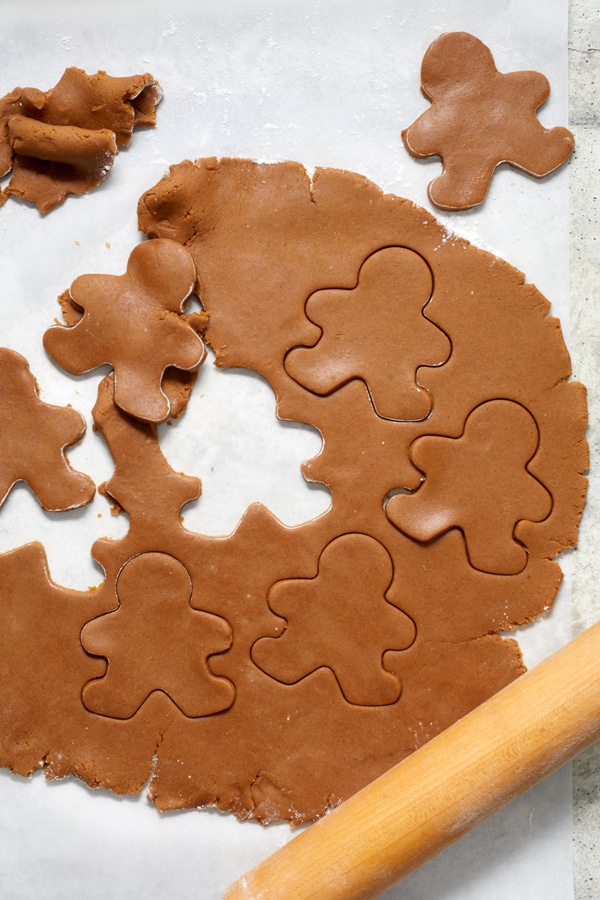 Gingerbread cookie dough rolled out on a surface.