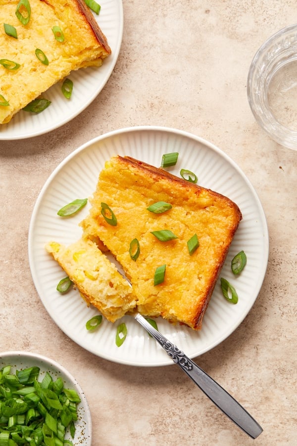 Two slices of Dairy Free Corn Casserole on white plates.