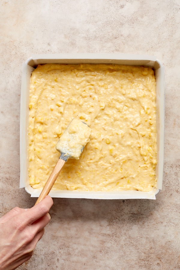 Batter spread in a white baking dish.