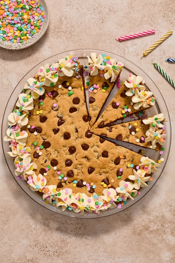 A Dairy Free Cookie Cake in a pie dish partially sliced.